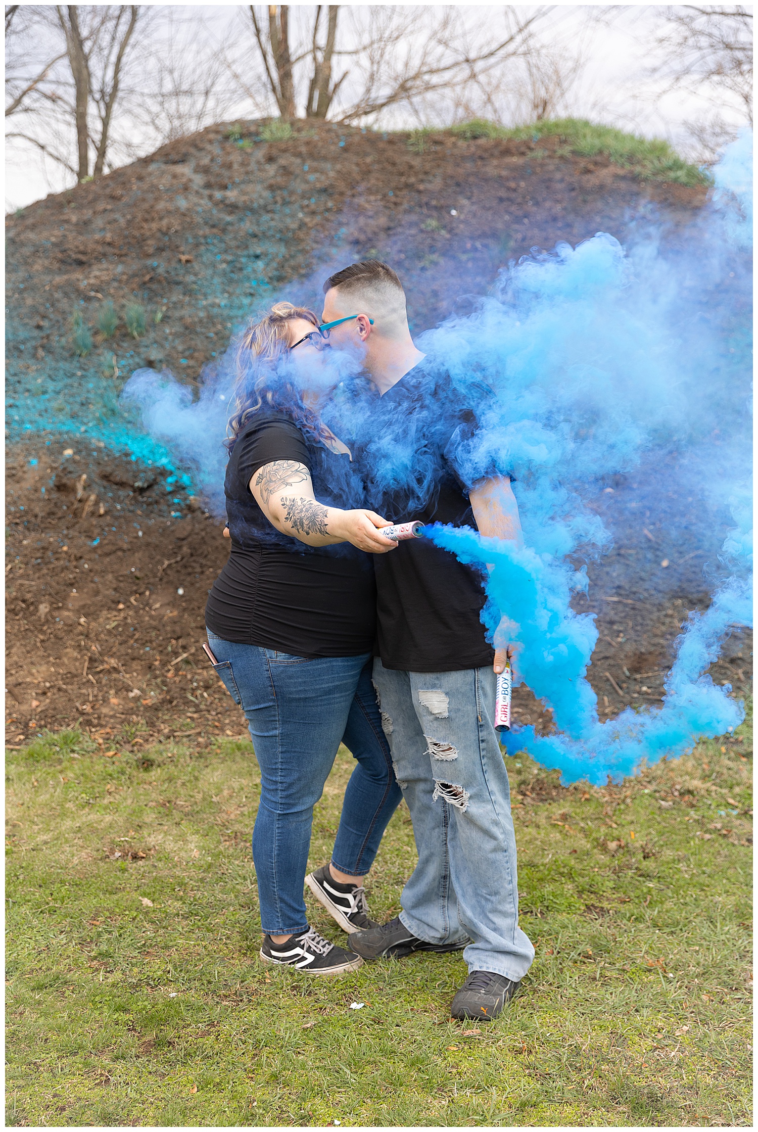 mother and father surrounded in blue gender reveal smoke bomb